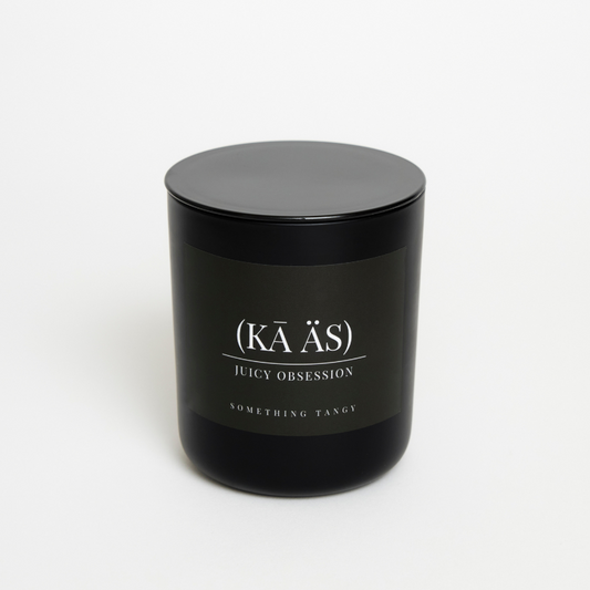14ounces juicy obsession citrus candle in a matte black vessel with lid something tangy