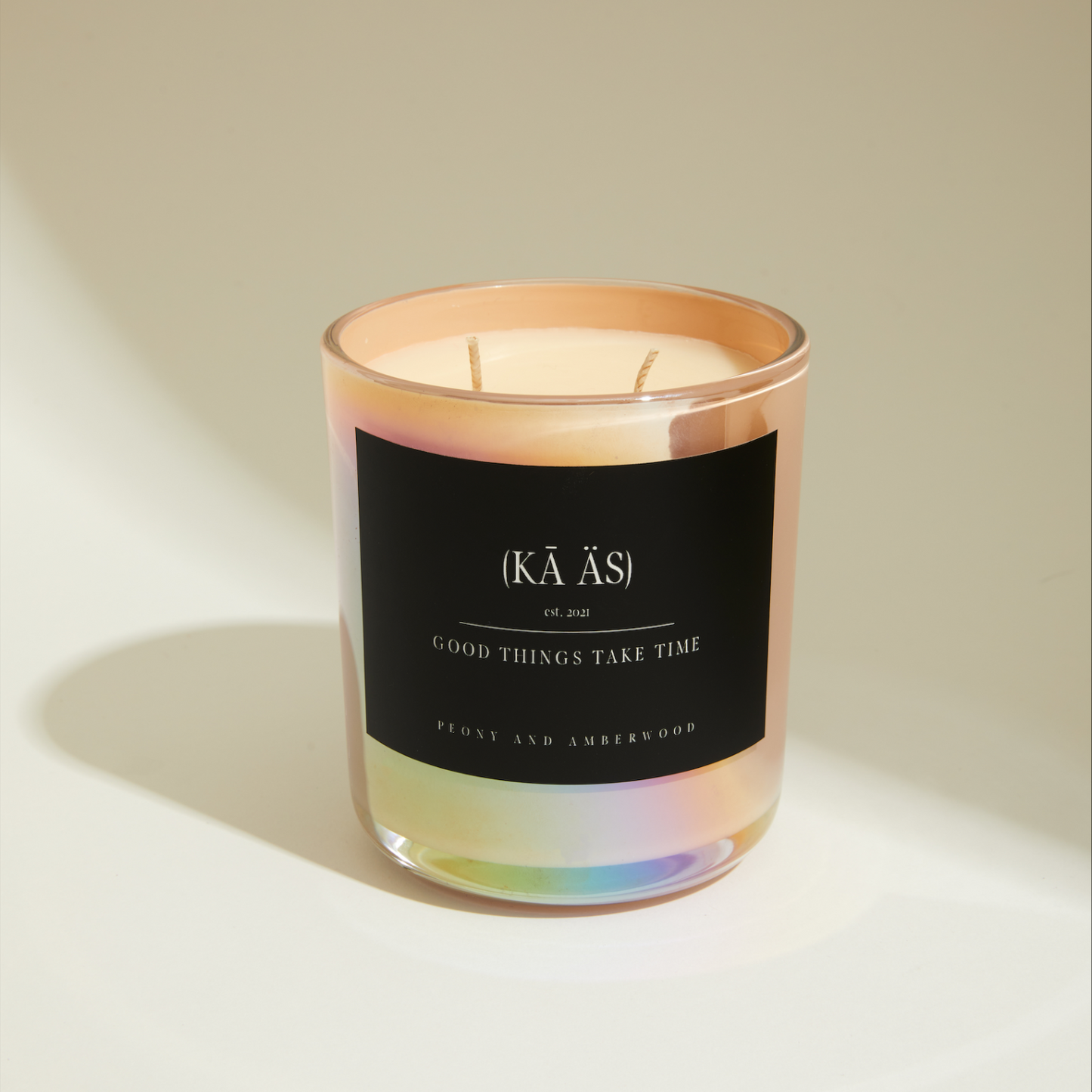 peony and amberwood scented candle, iridescent pink vessel.
